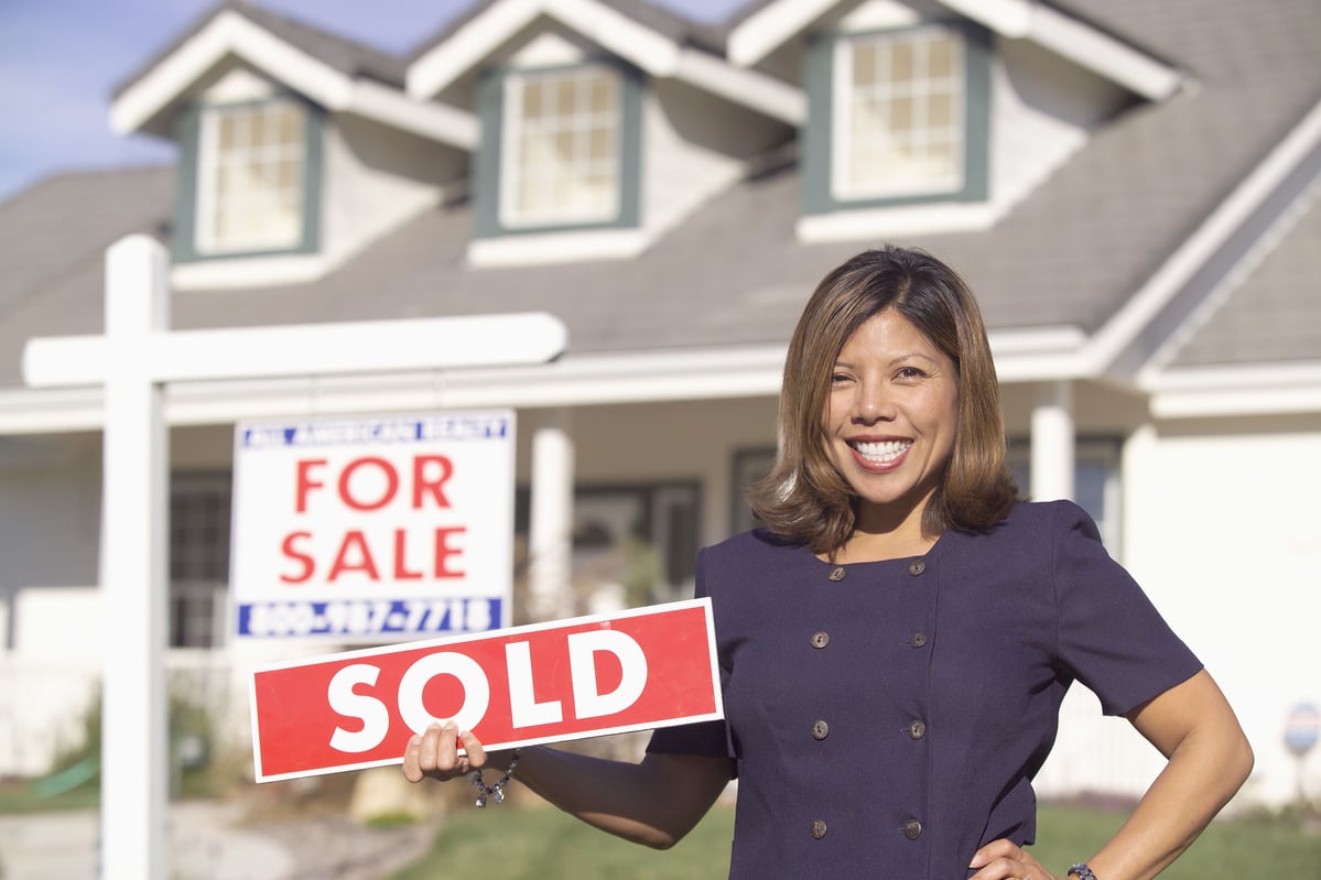 Real estate agent holding sign